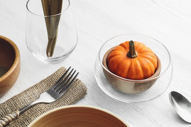 Photo of Autumn table setting with pumpkin on white wooden background, closeup