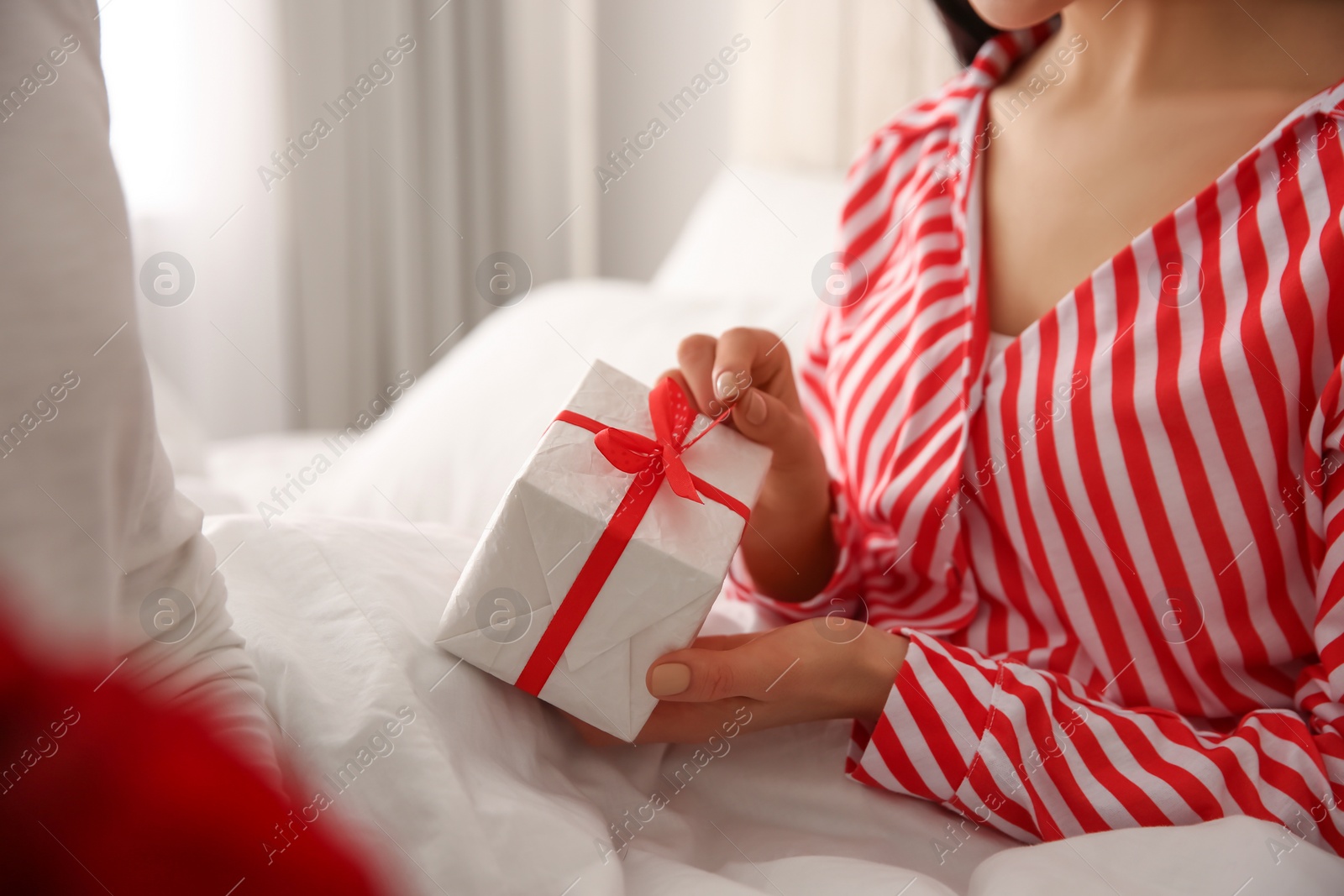 Photo of Lovely couple with gift box at home, closeup. Valentine's day celebration