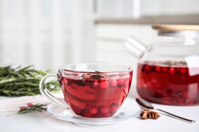 Photo of Tasty hot cranberry tea on white table