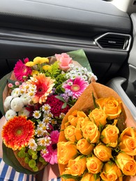 Photo of Woman with different bouquets of beautiful flowers in car, closeup