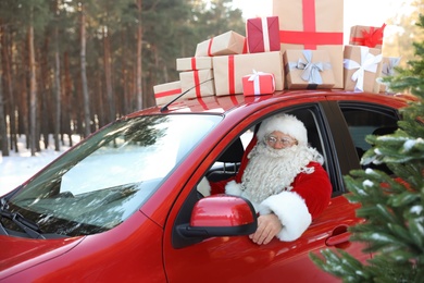 Photo of Authentic Santa Claus driving car with gift boxes, view from outside