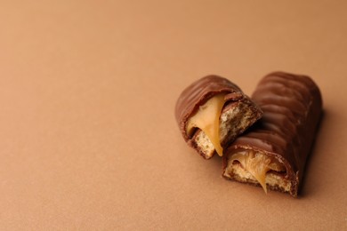 Pieces of chocolate bar with caramel on beige background. Space for text