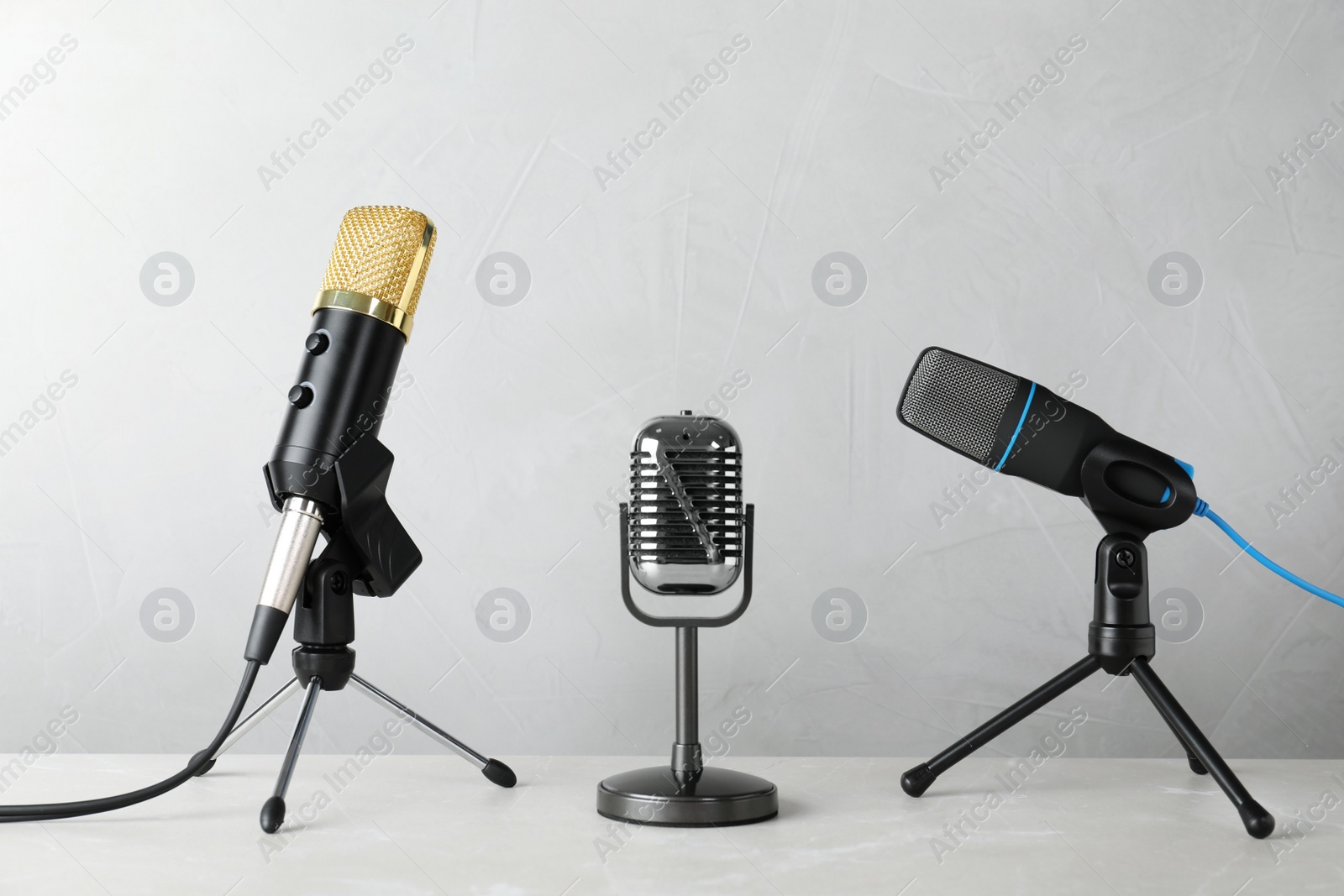 Photo of Different microphones on table against grey background