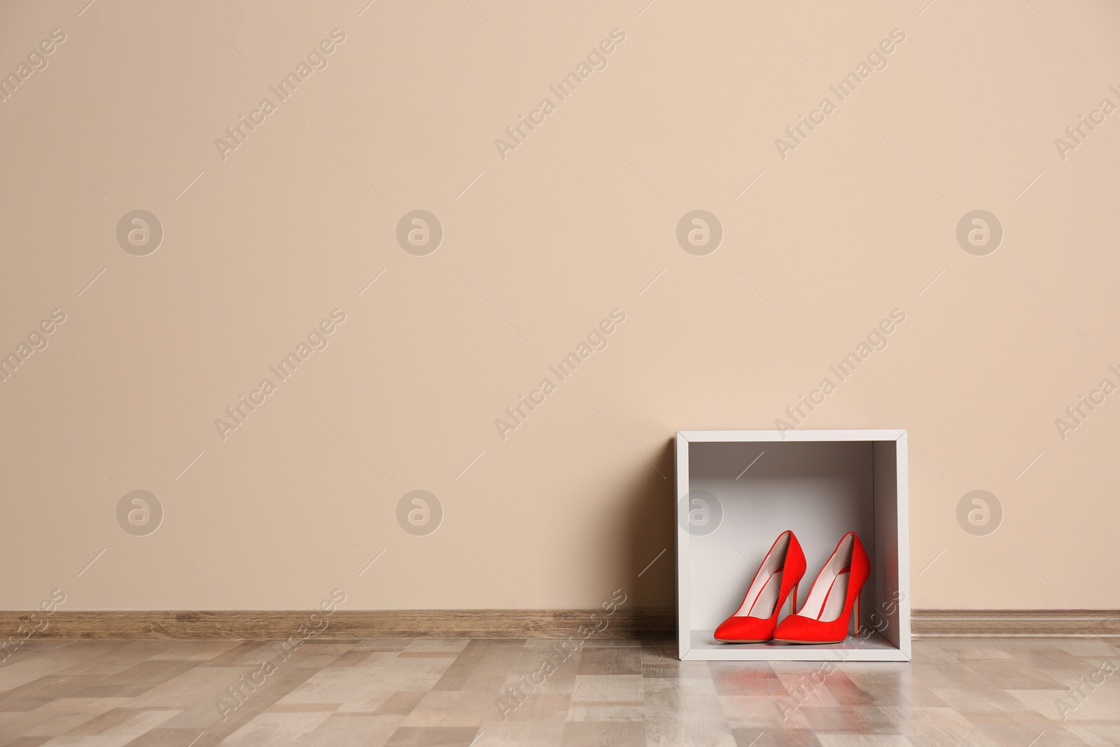 Photo of Modern cabinet with high heeled shoes near color wall, space for text