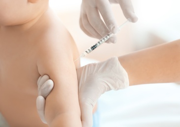 Photo of Doctor vaccinating baby in clinic, closeup