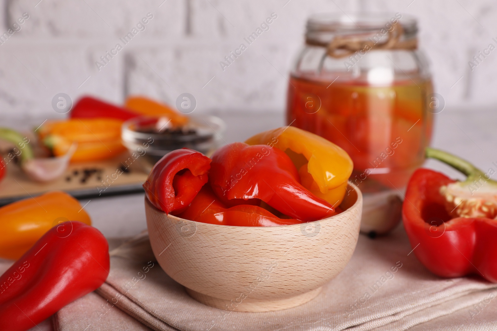Photo of Tasty pickled peppers and fresh vegetables on table