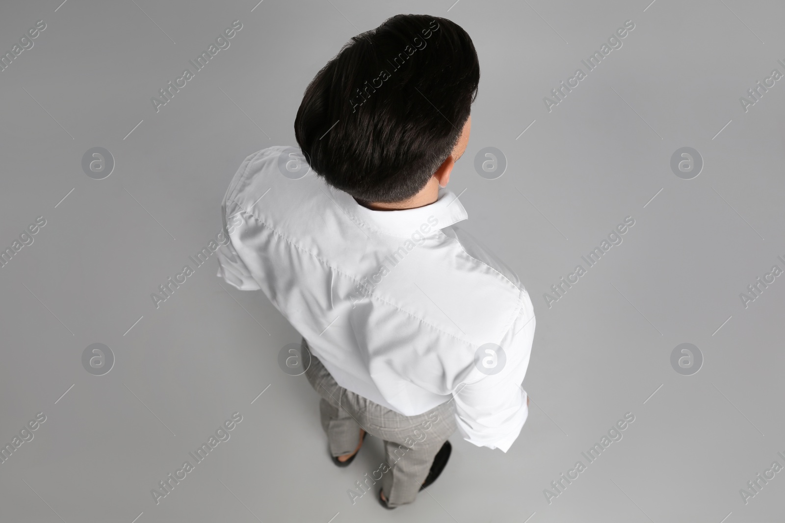 Photo of Businessman in formal clothes on grey background, back view