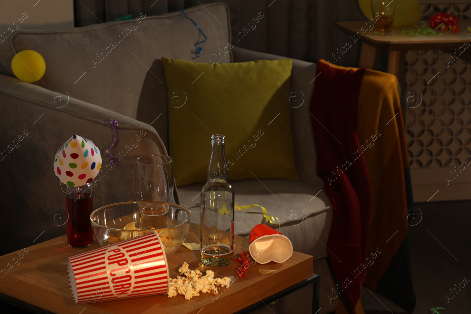 Photo of Armchair and dirty table in messy room after party