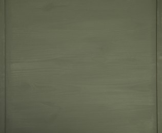 Photo of Texture of dark green wooden surface on table, top view