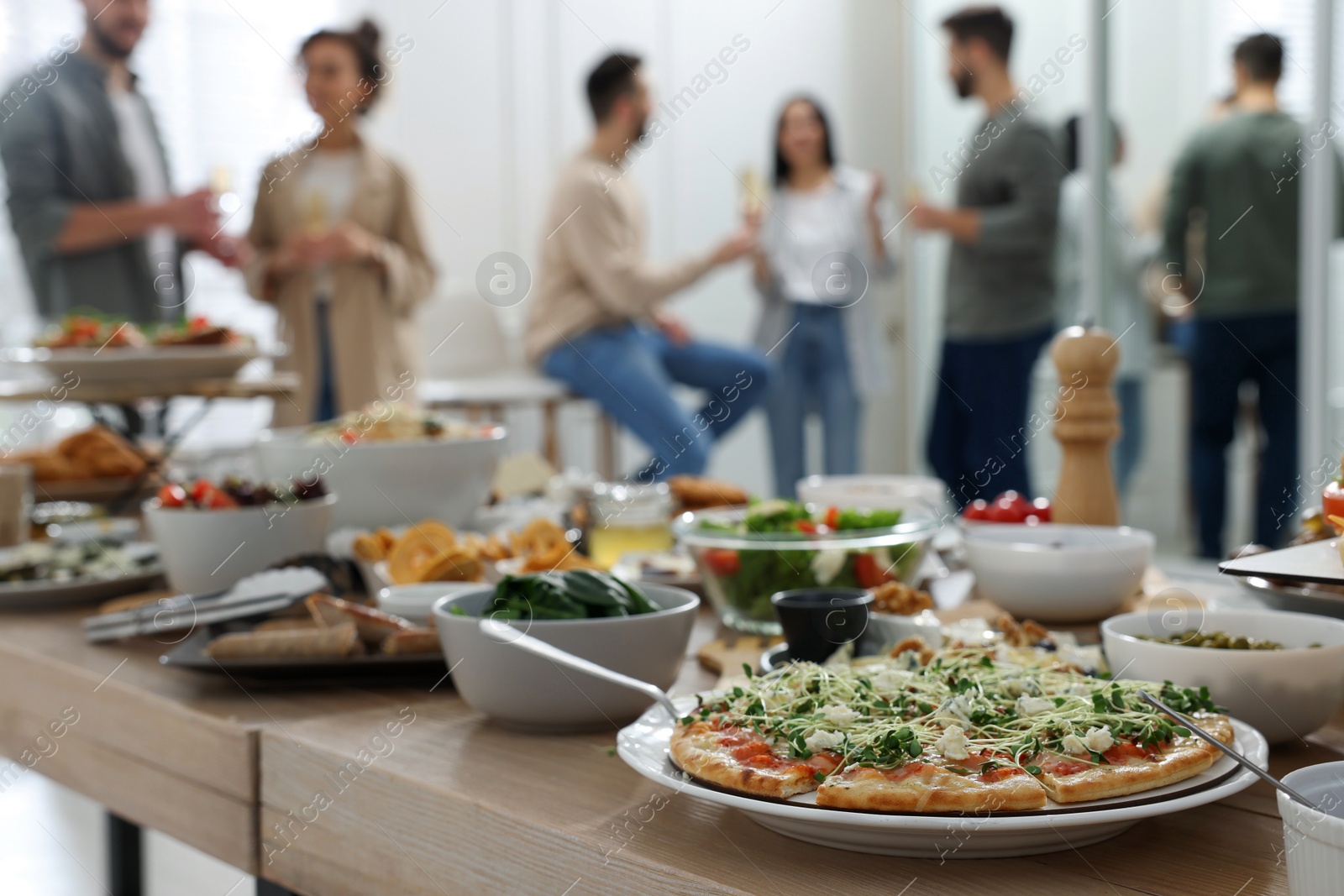 Photo of Brunch table setting with different delicious food	and blurred view of people on background