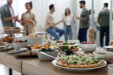 Photo of Brunch table setting with different delicious food	and blurred view of people on background