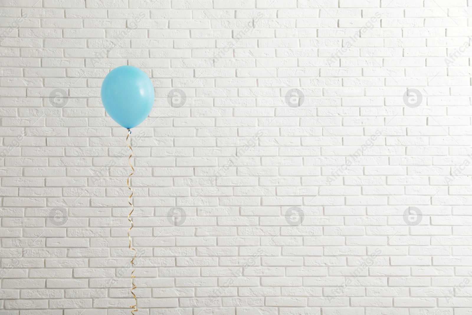 Photo of Bright balloon near brick wall, space for text. Celebration time