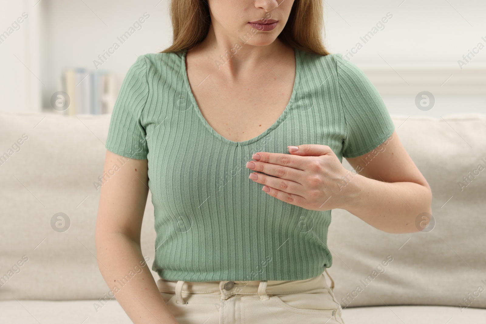 Photo of Mammology. Young woman doing breast self-examination at home, closeup