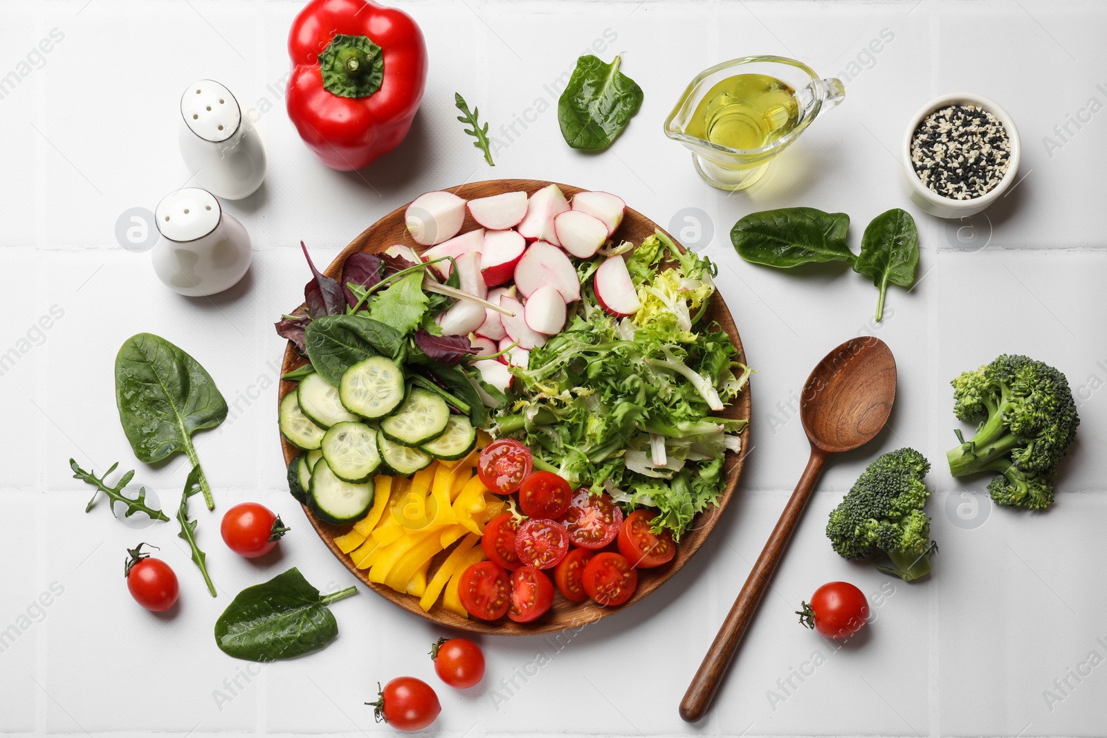 Photo of Vegetarian diet. Plate with tasty vegetables and spoon at white tiled table, flat lay