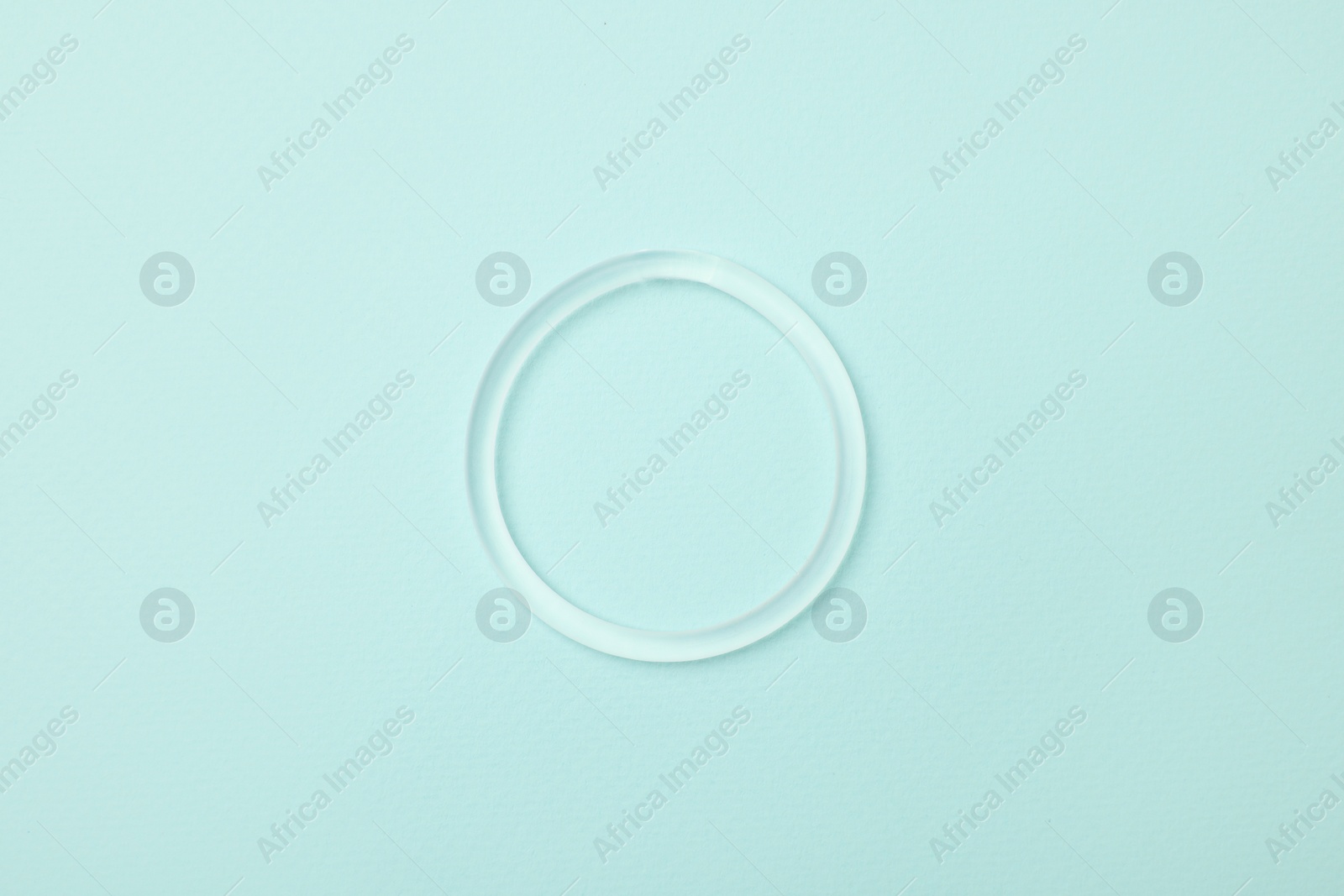 Photo of Diaphragm vaginal contraceptive ring on light blue background, top view