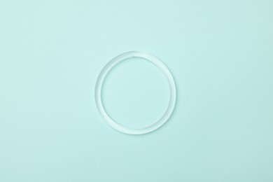 Photo of Diaphragm vaginal contraceptive ring on light blue background, top view