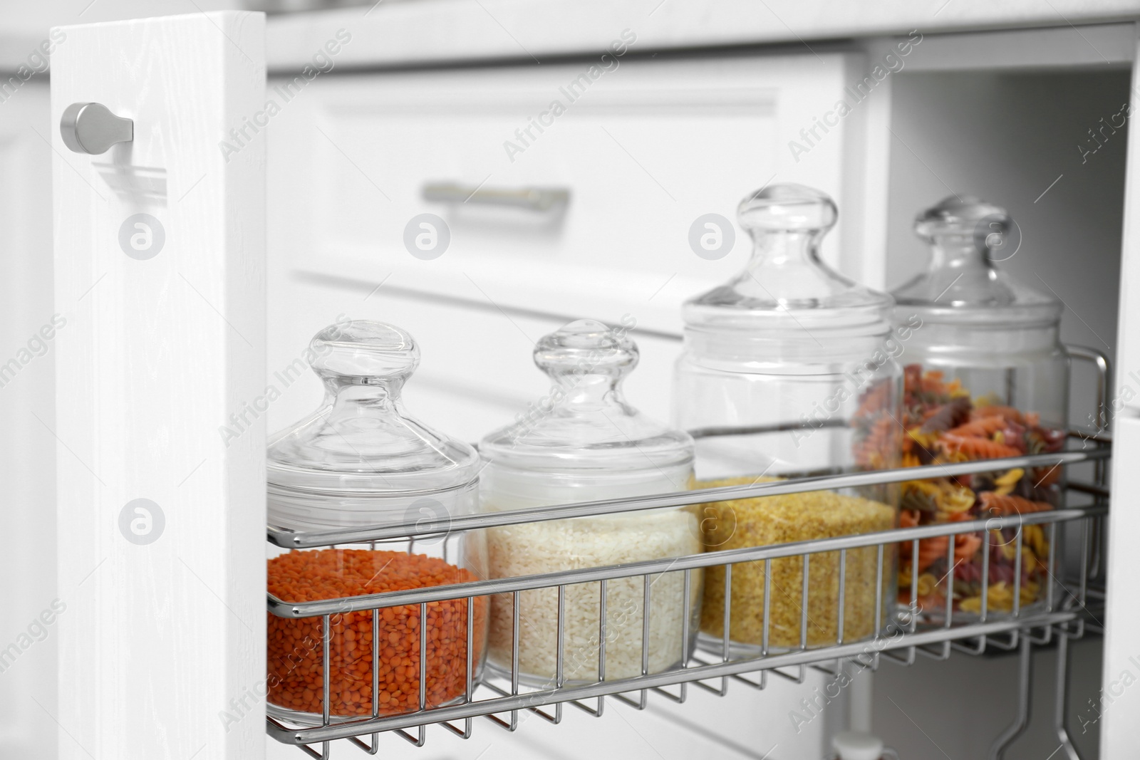 Photo of Shelf with different jars indoors. Order in kitchen