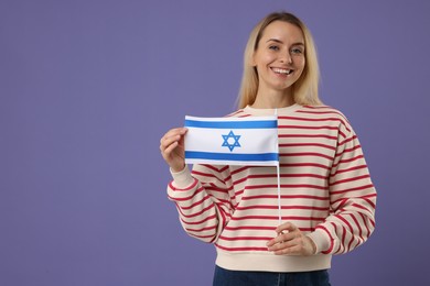 Happy woman with flag of Israel on violet background, space for text