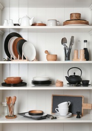 Photo of White shelving unit with set of dishware