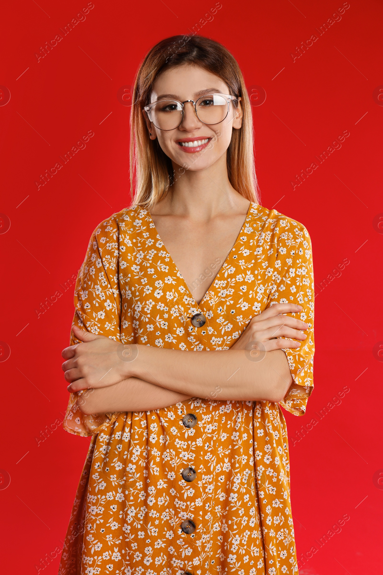 Photo of Portrait of young woman with glasses on red background