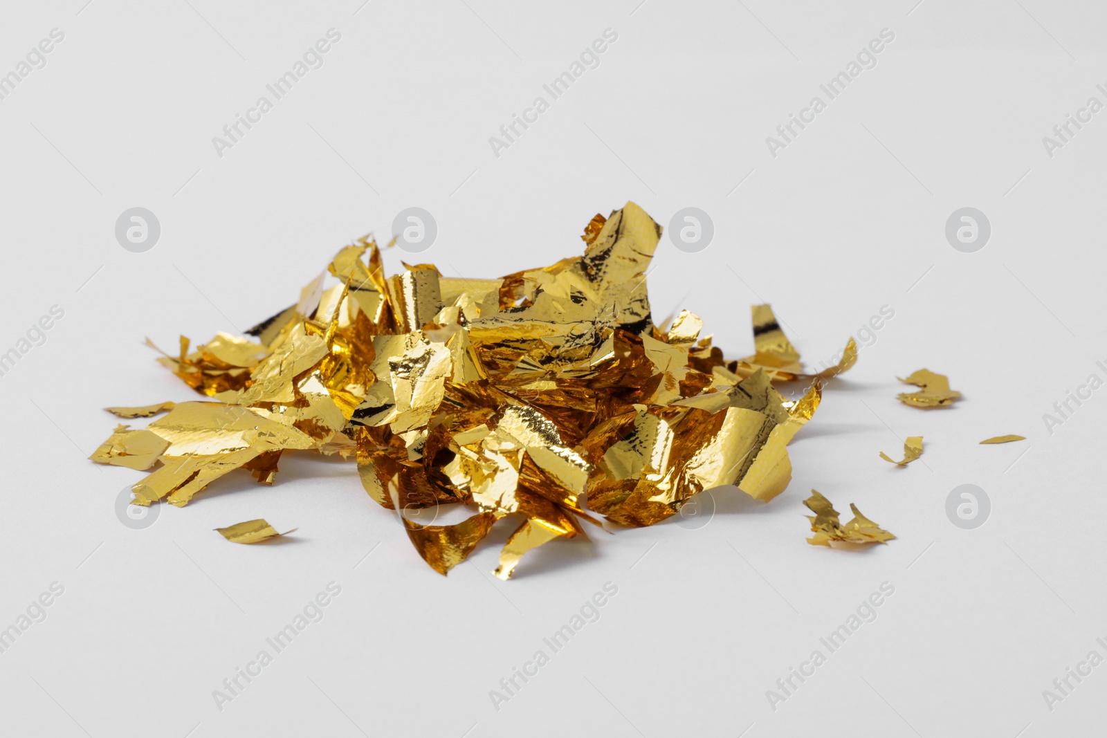 Photo of Pile of edible gold leaf on white background