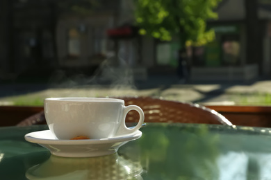 Photo of Cup of fresh aromatic coffee at table in cafe