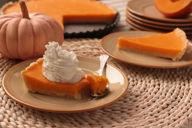 Piece of fresh homemade pumpkin pie with whipped cream on table