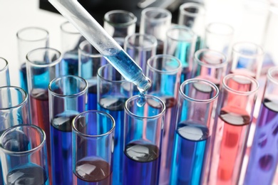 Photo of Dripping reagent into test tube with sample in chemistry laboratory, closeup