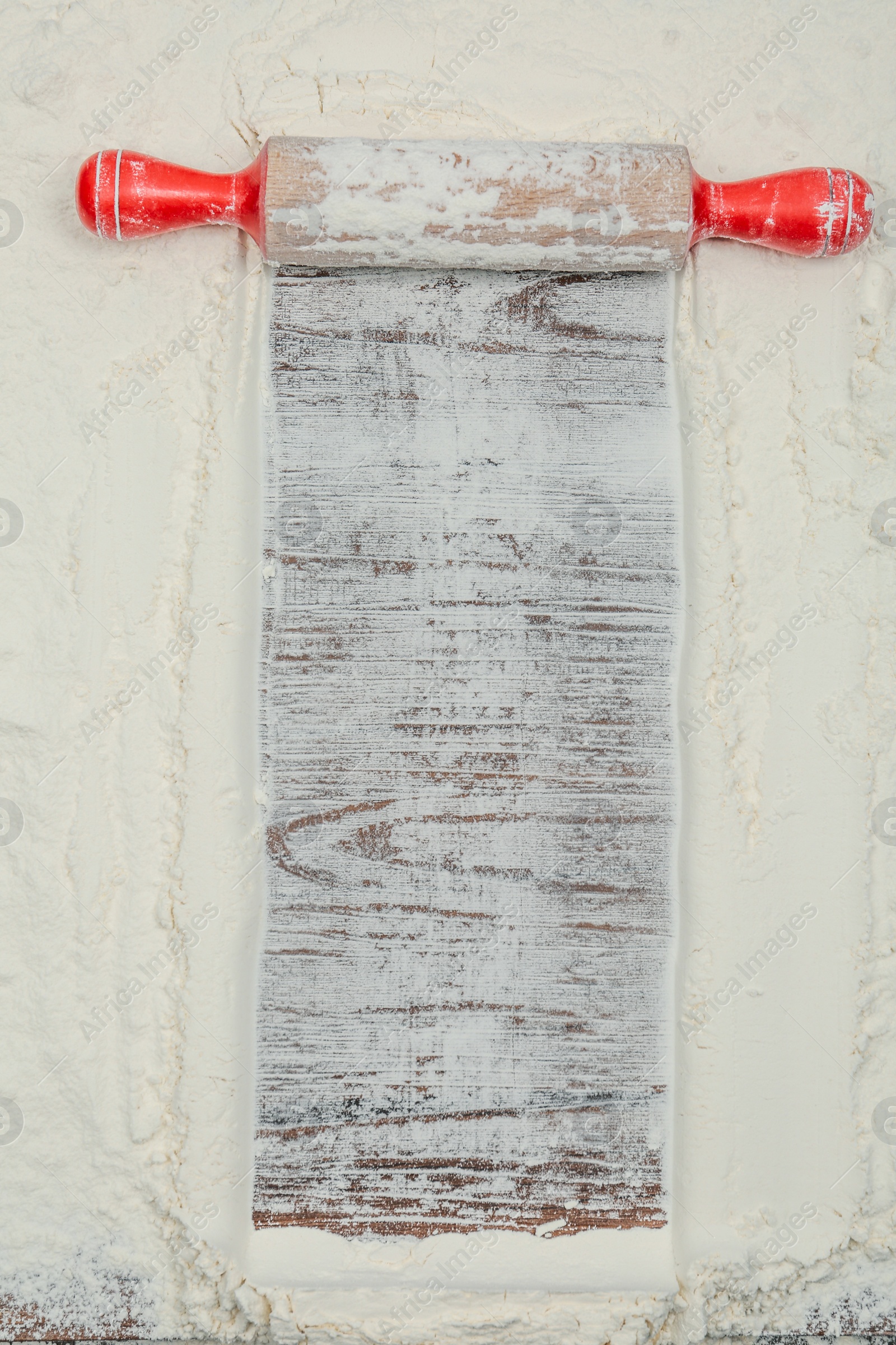 Photo of Flour and rolling pin on wooden table, top view. Space for text