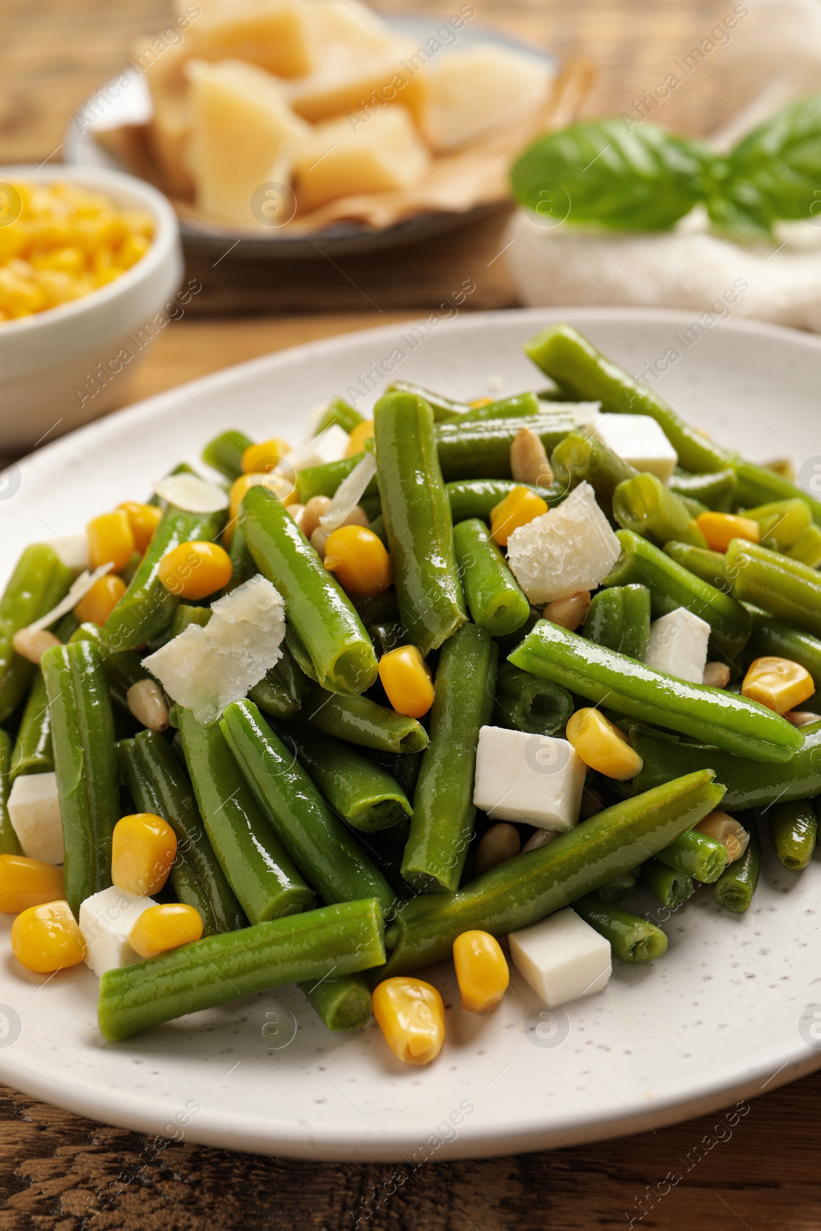 Photo of Delicious salad with green beans, corn and cheese on table, closeup