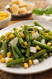 Delicious salad with green beans, corn and cheese on table, closeup