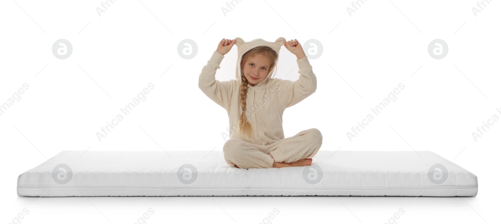 Photo of Little girl sitting on mattress against white background