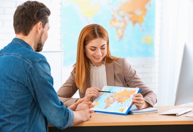 Photo of Female manager consulting client in travel agency