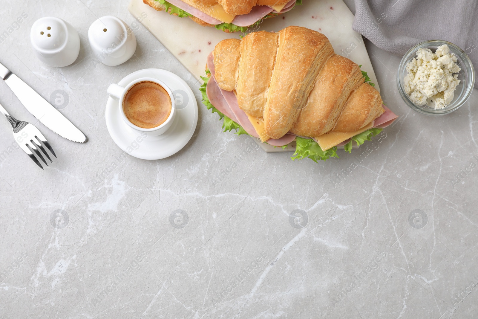 Photo of Tasty croissant sandwich with ham served on grey table, flat lay. Space for text