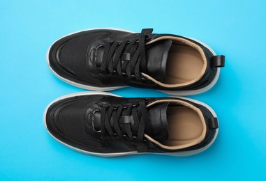 Photo of Pair of stylish shoes on blue background, top view