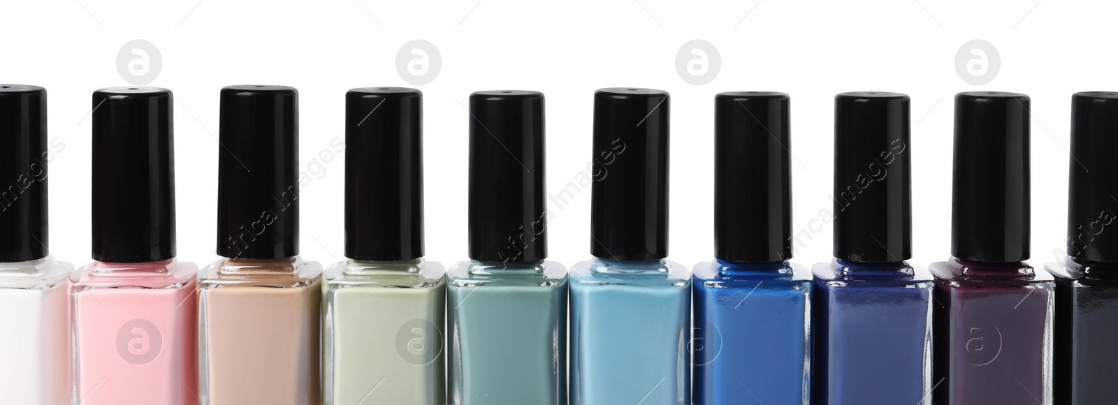 Photo of Beautiful nail polishes in bottles isolated on white