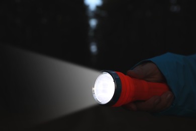 Image of Man with bright flashlight in darkness, closeup