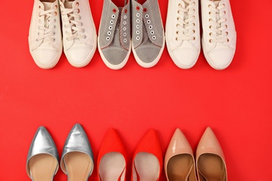 Photo of Flat lay composition with different bright shoes on red background. Space for text