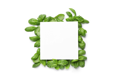Photo of Green basil leaves and blank card on white background, top view. Space for text