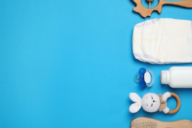 Photo of Flat lay composition with pacifier and other baby stuff on light blue background. Space for text