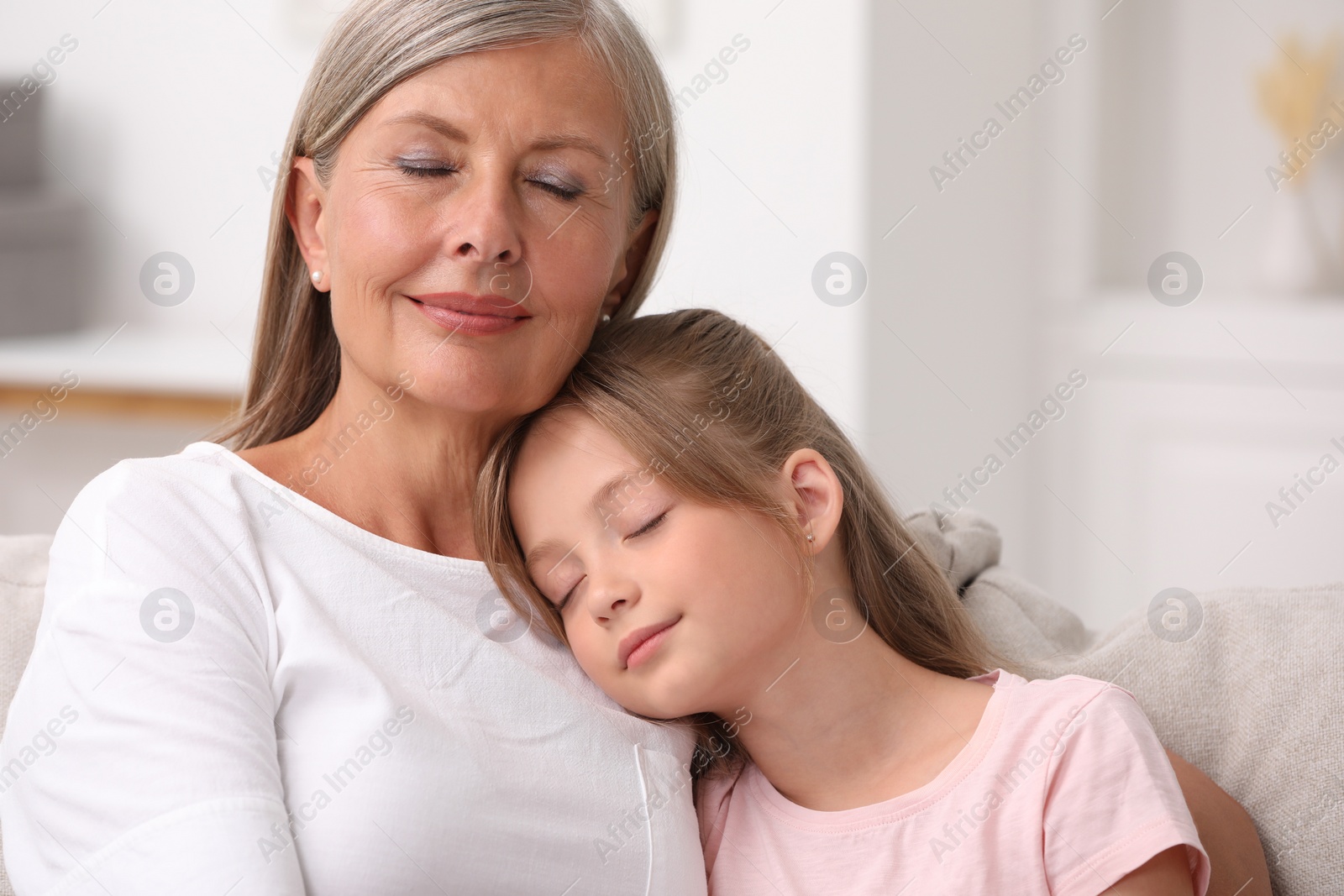 Photo of Happy grandmother with her granddaughter at home, space for text