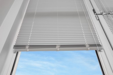 Photo of Stylish window with horizontal blinds, low angle view
