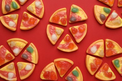 Photo of Tasty jelly candies in shape of pizza on red background, flat lay