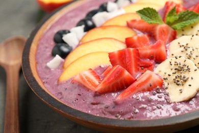 Delicious acai smoothie with fresh fruits on table, closeup