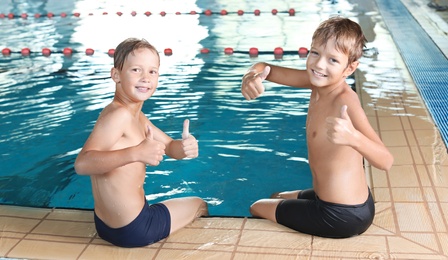 Photo of Cute little boys near indoor swimming pool