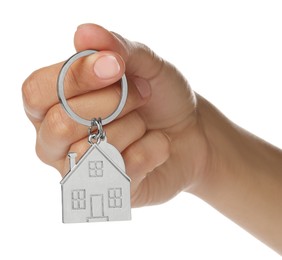 Photo of Woman holding metallic keychain in shape of house on white background, closeup