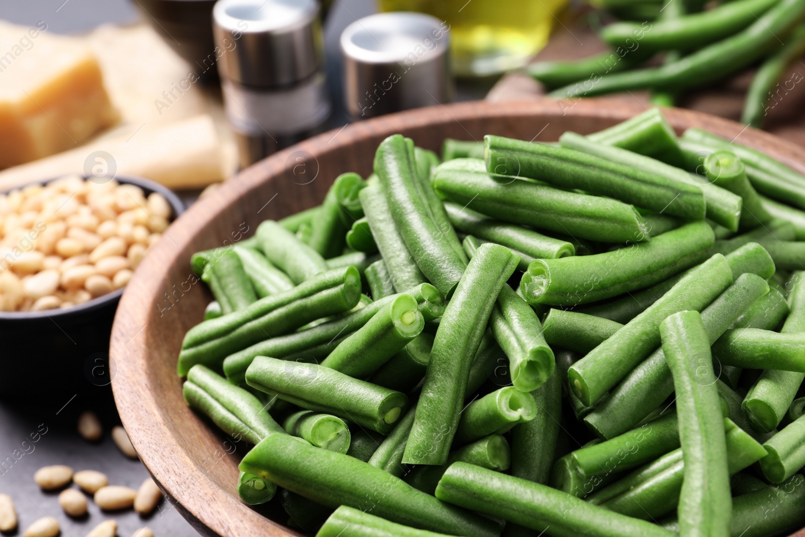 Photo of Fresh raw green beans and other ingredients for salad on table, closeup