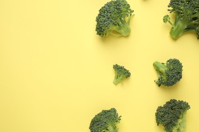 Fresh tasty broccoli on yellow background, flat lay. Space for text