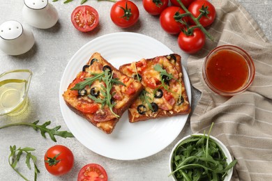 Photo of Tasty pizza toast and ingredients on grey table, flat lay