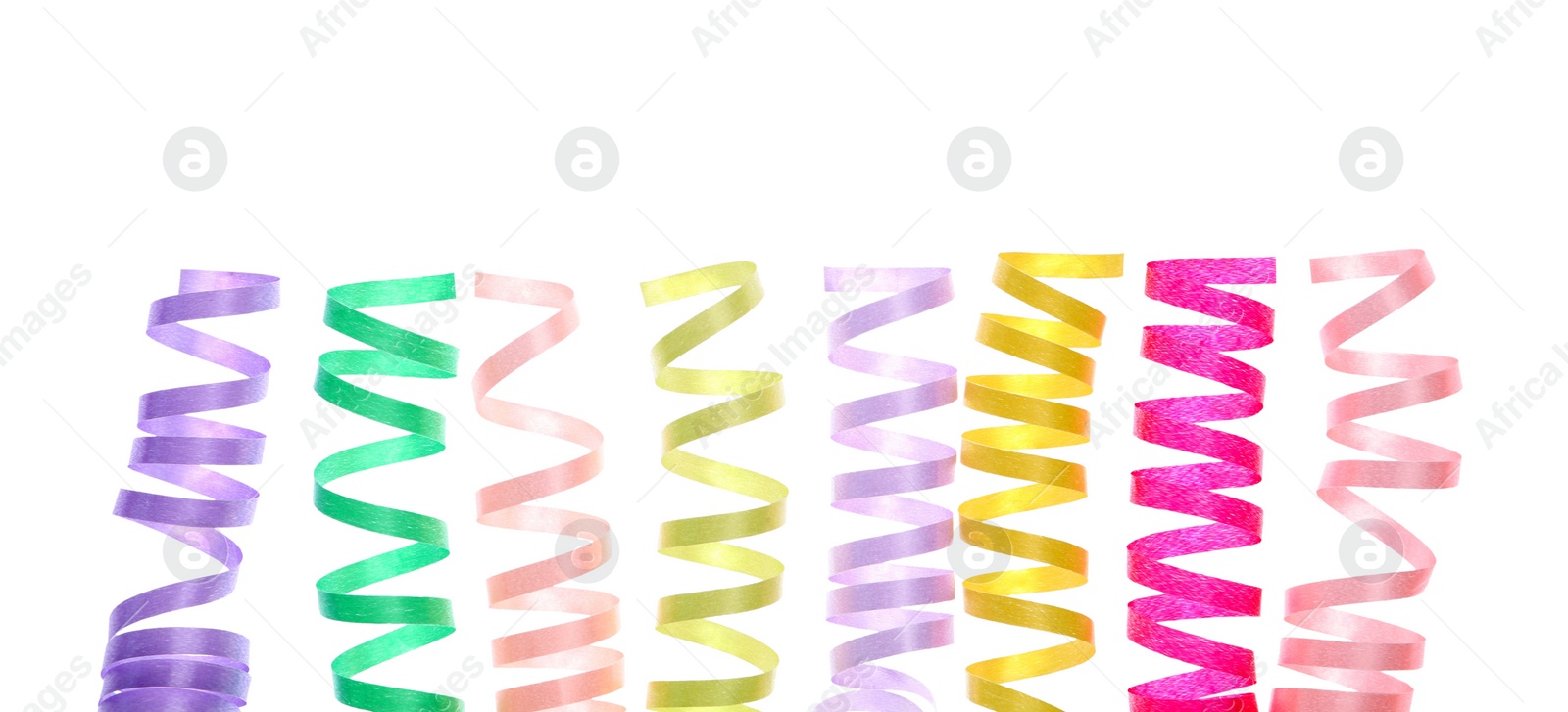 Photo of Bright serpentine streamers on white background. Festive decor